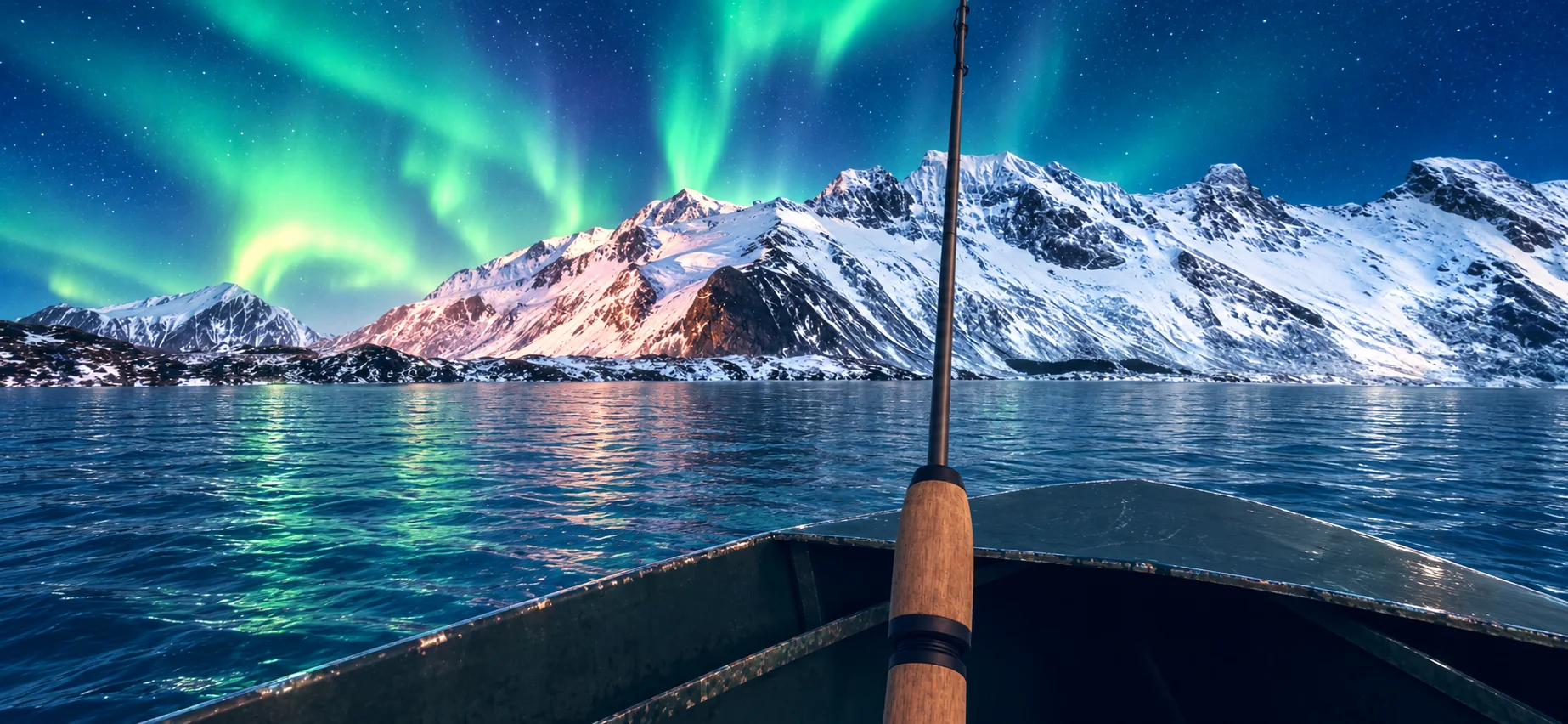 Fishing beneath the northern lights and snowy mountains in Alaska